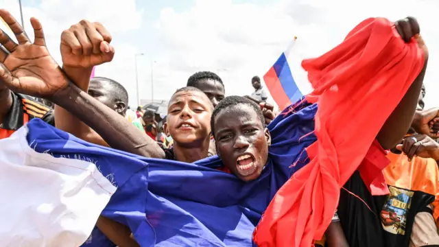 Manifestation pro-russe à Niamey en 2023, montrant un homme agitant un drapeau russe