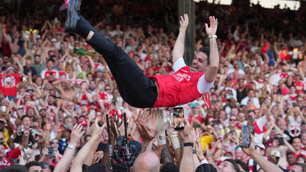 L'entraîneur d'Arsenal, Mikel Arteta, est porté en triomphe par les joueurs qui célèbrent leur titre de champion de Premier League après le match de football de Premier League anglaise entre Crystal Palace et Arsenal à Londres, en Angleterre, le dimanche 24 mai 2026.