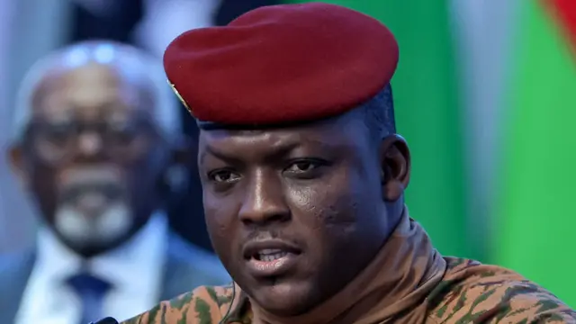 Portrait du capitaine Ibrahim Traoré en tenue militaire beige et béret rouge, lors d'une interview télévisée.