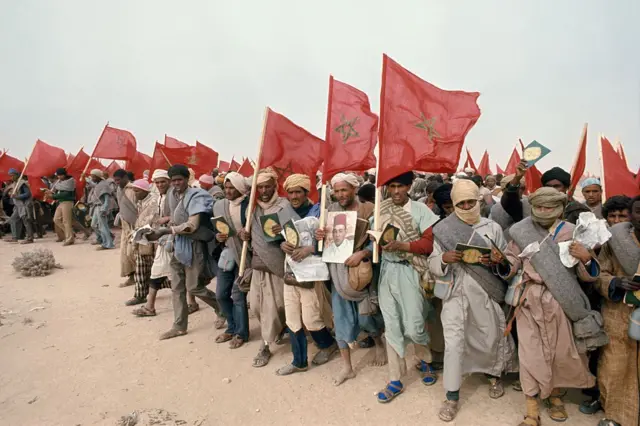 Participants de la Marche verte de 1975 brandissant des drapeaux marocains